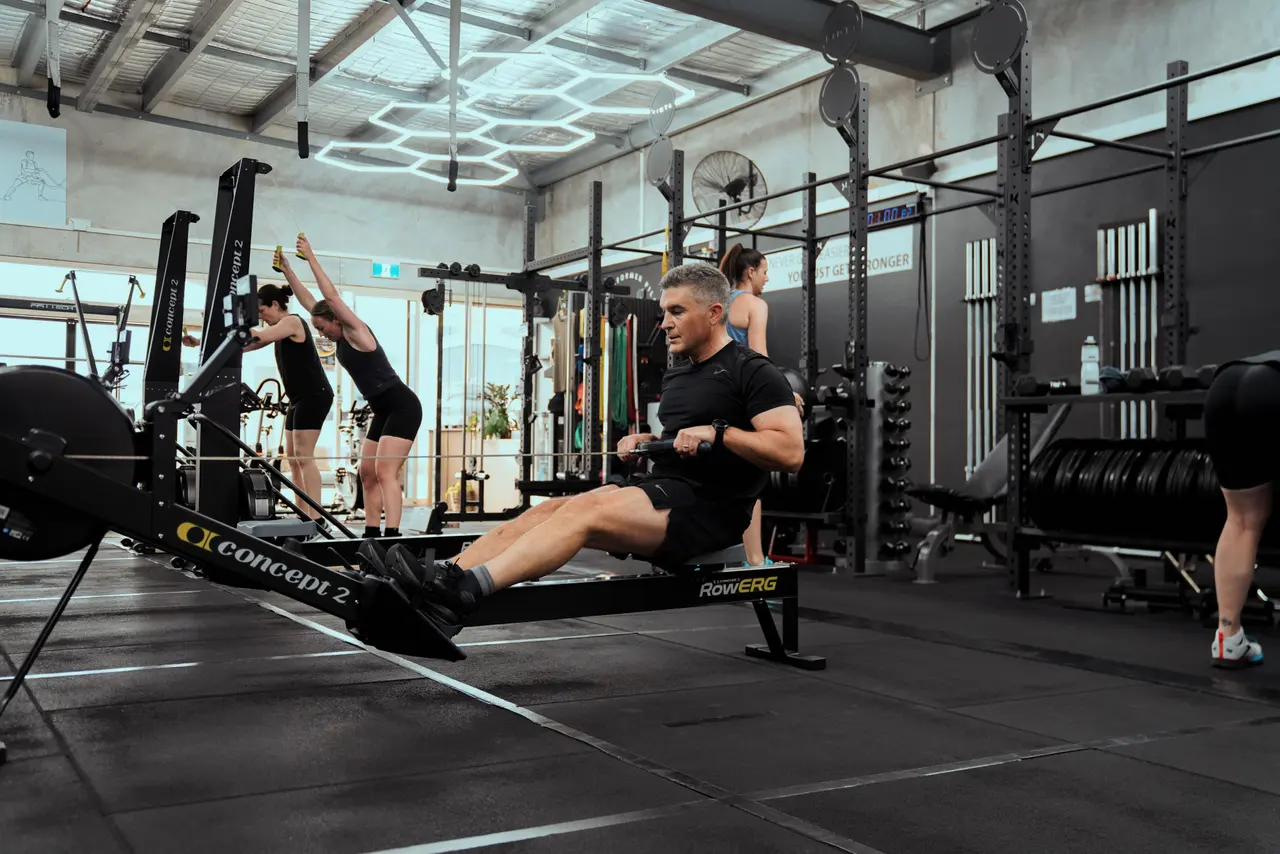 Members training on the studio floor beneath the hex ceiling lights